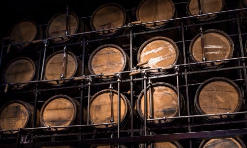 Wooden barrels lined up on wall.